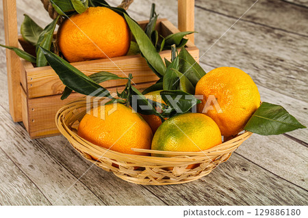 Ripe sweet tangerines heap with leaves 129886180
