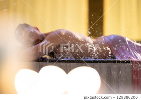 Man receiving water therapy inside a traditional Turkish hammam with ornate details. Man receiving water therapy inside a traditional Turkish hammam with ornate details. 129886200