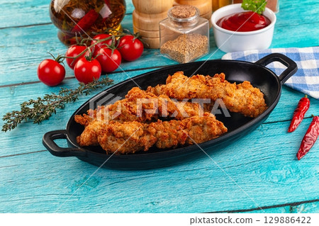 Golden crispy fried chicken strips 129886422