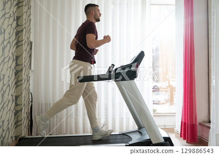 Running Therapy Indoors on Treadmill.Man running indoors on treadmill as part of a physical recovery program. Running Therapy Indoors on Treadmill.Man running indoors on treadmill as part of a physical recovery program. 129886543