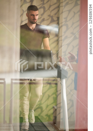 Treadmill Walking Therapy Session.Patient visible through glass walking on treadmill as part of rehabilitation treatment. Treadmill Walking Therapy Session.Patient visible through glass walking on treadmill as part of rehabilitation treatment. 129886594