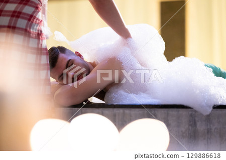 Foam Massage Session.Hamam attendant applying foam massage on patient back with circular motions. 129886618