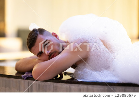 Man Relaxing in Foam.Relaxed man lying in Turkish bath covered in white foam during cleansing ritual. Man Relaxing in Foam.Relaxed man lying in Turkish bath covered in white foam during cleansing ritual. 129886679