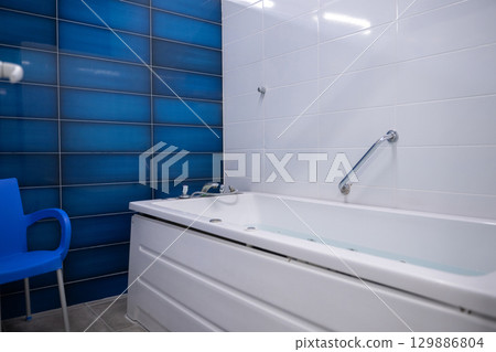 Jacuzzi bathtub in a therapy room, clean and ready for a relaxation or medical spa treatment. Jacuzzi bathtub in a therapy room, clean and ready for a relaxation or medical spa treatment. 129886804