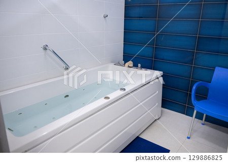 Jacuzzi bathtub in a therapy room, clean and ready for a relaxation or medical spa treatment. Jacuzzi bathtub in a therapy room, clean and ready for a relaxation or medical spa treatment. 129886825