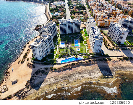 Aerial view of Punta Prima coastline. Spain 129886930