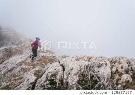 Trail Runner in Misty Mountain Landscape 129887157