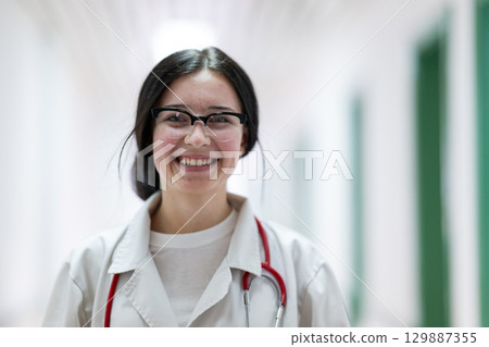 Doctor smiling in hospital hallway Doctor smiling in hospital hallway 129887355