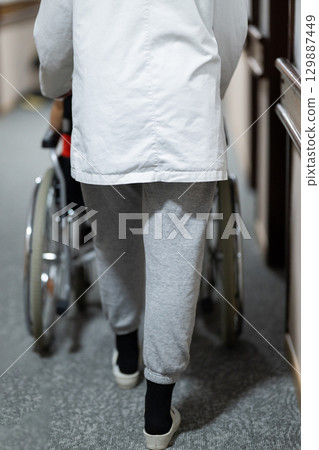 Young Male Patient in Wheelchair Assisted by Female Medical Professional 129887449