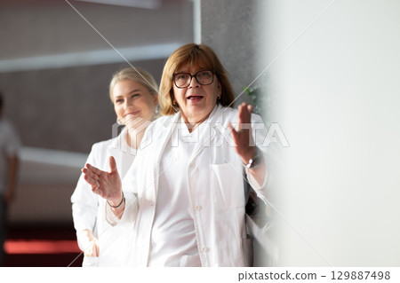 Portrait of smiling young female doctor wearing white coat, medical healthcare professional concept 129887498