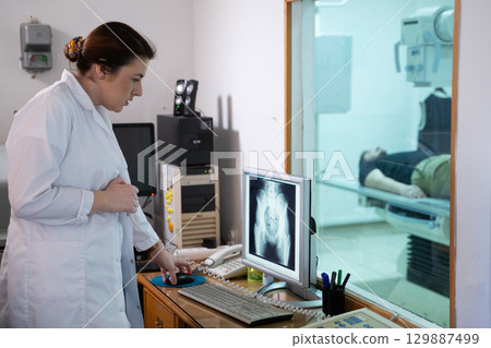 Radiologist Analyzing X Ray Scans in a Medical Imaging Room. Radiologist Analyzing X Ray Scans in a Medical Imaging Room. 129887499