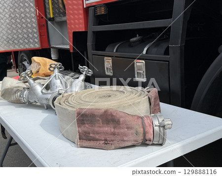 A water fire hose is lying on the lawn. High quality photo A water fire hose is lying on the lawn. High quality photo 129888116