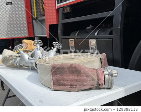 A water fire hose is lying on the lawn. High quality photo A water fire hose is lying on the lawn. High quality photo 129888118