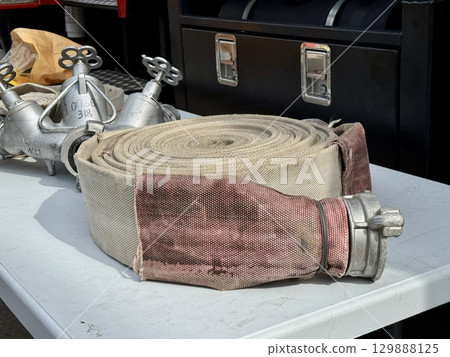 A water fire hose is lying on the lawn. High quality photo A water fire hose is lying on the lawn. High quality photo 129888125