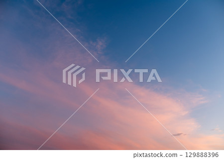Evening sky with colorful clouds after sunset. Background of clouds melting with vibrant colour in sky 129888396