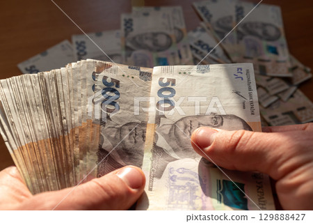 Man counting ukrainian hryvnia money. 500 hryvnia banknotes, counting big sum, getting ready for a big purchase 129888427