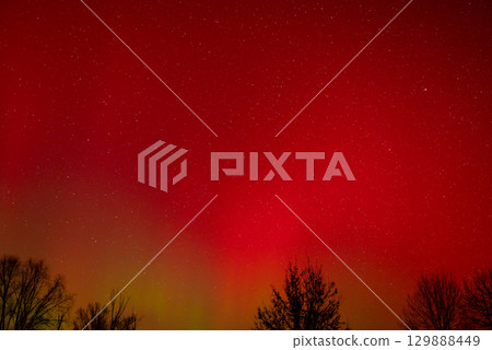 Red bright northern lights in the sky. Photo of bright aurora lights Red bright northern lights in the sky. Photo of bright aurora lights 129888449