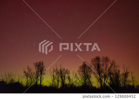Night sky with green and red color of Northern lights. Aurora lights illuminating sky with vivid color Night sky with green and red color of Northern lights. Aurora lights illuminating sky with vivid color 129888452