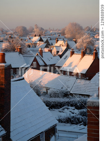 snow covered village rooftops at sunrise 129888939