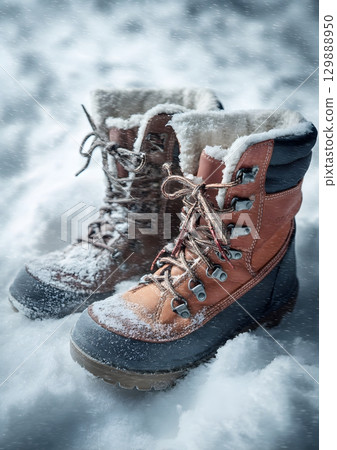 winter boots standing in deep snow 129888950