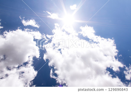 Bright sun and blue sky with clouds. Concept of abnormal heat Bright sun and blue sky with clouds. Concept of abnormal heat 129890843