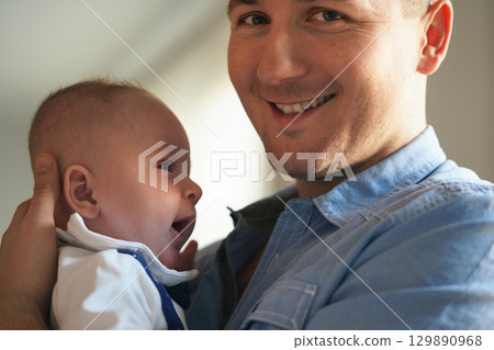 Young man holding his baby son on arms, closeup detail 129890968