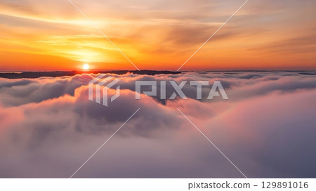 view of the sunrise over a sea of clouds with a colorful sky above it 129891016