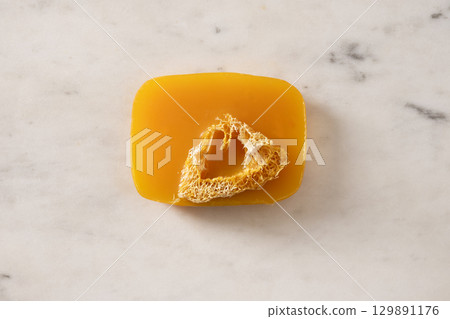 Turmeric soap bar on marble white background. Organic skincare product and bath accessories. View from above. Vertical. 129891176