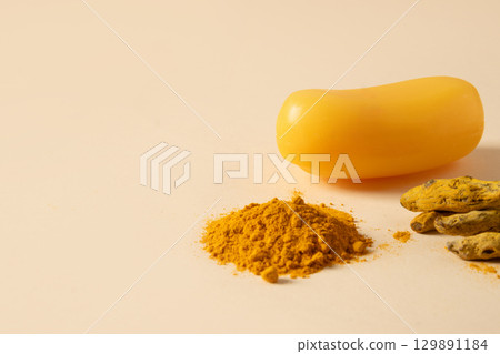 Handmade turmeric soap bars, powder and turmeric root on yellow background. Organic skincare product perfect for wellness, beauty, and organic body care concepts. Close up. Copy space 129891184