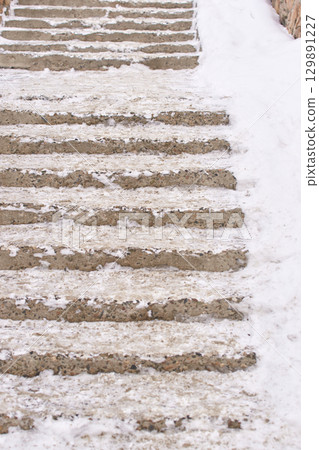 Snow covered concrete steps with light dusting of snow and ice in winter setting 129891227