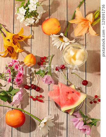 Abstract flower arrangement, background, holiday concept with flowers, autumn and summer banner. Flowers lilies, mint, mallow, daisies, apples, melons, cherries and watermelon on a sunny table, Abstract flower arrangement, background, holiday concept with flowers, autumn and summer banner. Flowers lilies, mint, mallow, daisies, apples, melons, cherries and watermelon on a sunny table, 129891736