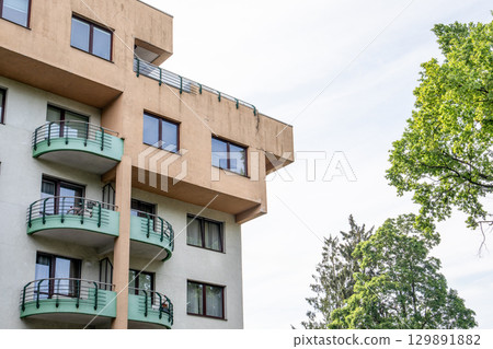 Modern Apartment Building with Balconies and Trees in a Residential Urban Neighborhood Modern Apartment Building with Balconies and Trees in a Residential Urban Neighborhood 129891882