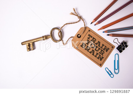 Train Your Brain Motivation Message on Label With Vintage Key and Stationery on White Background 129891887