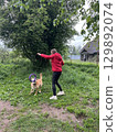 Joyful moments in the park with a playful dog and owner enjoying their time outdoors during a cloudy day in spring 129892074