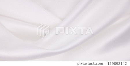 Smooth elegant white silk or satin luxury cloth texture as wedding background. Luxurious background design 129892142