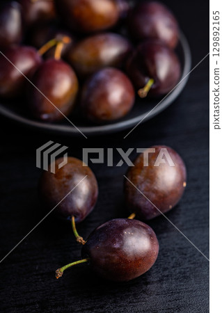 Ripe plums on black table. Ripe plums on black table. 129892165