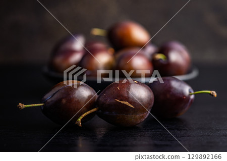 Ripe plums on black table. Ripe plums on black table. 129892166