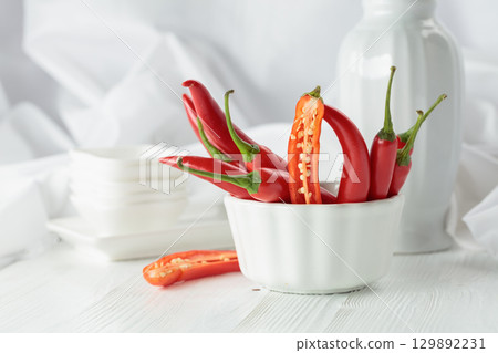 Fresh red chili peppers with on a white wooden table. 129892231