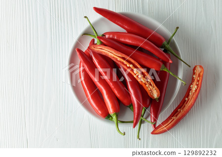 Fresh red chili peppers with on a white wooden table. 129892232