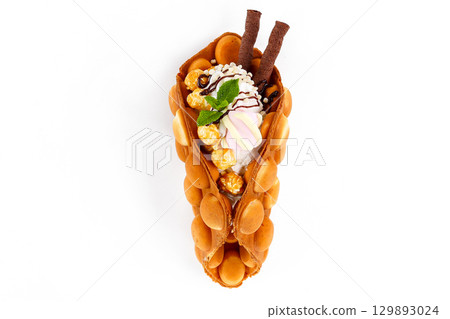 Vanilla Bubble Waffle Dessert with Popcorn, Marshmallow, Whipped Cream, and Chocolate Sticks 129893024