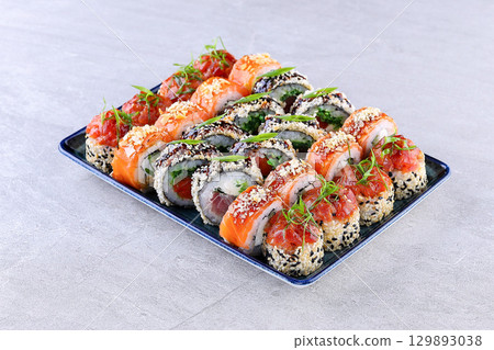 Assorted Sushi Roll Platter with Salmon, Tuna, Seaweed, and Sesame Garnishes 129893038
