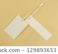 Two white empty labels on a beige background. Tags for prices or product names. 129893653