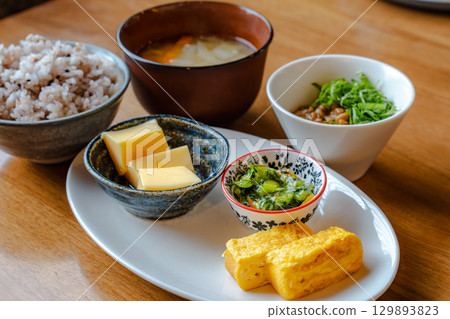 日本早餐套餐,包括雜糧米飯、味噌湯、玉子燒(蛋捲)和一份小菜。 日本早餐套餐,包括雜糧米飯、味噌湯、玉子燒(蛋捲)和一份小菜。 129893823