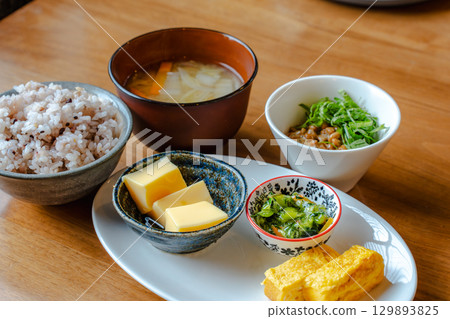 日本早餐套餐,包括雜糧米飯、味噌湯、玉子燒(蛋捲)和一份小菜。 日本早餐套餐,包括雜糧米飯、味噌湯、玉子燒(蛋捲)和一份小菜。 129893825