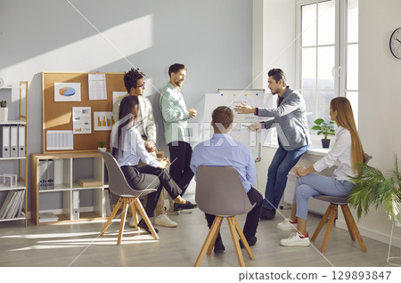 Group of business people chatting on a meeting sitting in circle in office discussing work project. Group of business people chatting on a meeting sitting in circle in office discussing work project. 129893847