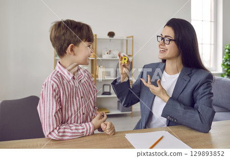 Speech therapist and boy patient training articulation in office Speech therapist and boy patient training articulation in office 129893852