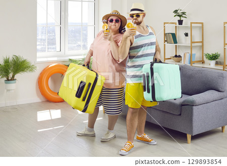 Happy couple of fat woman and smiling man in hats and sunglasses getting ready for holiday trip. 129893854