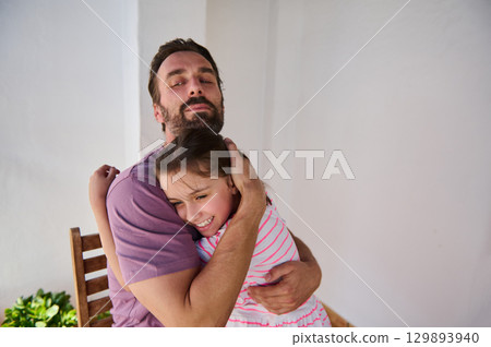 A heartfelt scene of a father embracing his young daughter, showcasing love and family connection. The joyful expression captures the cherished bond between them, emphasizing care and affection. 129893940