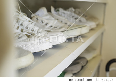 Sneakers stored in a shoe closet 129894298