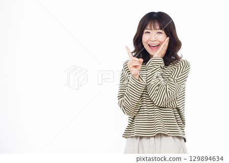 A woman who raises her index finger with a smile A woman who raises her index finger with a smile 129894634